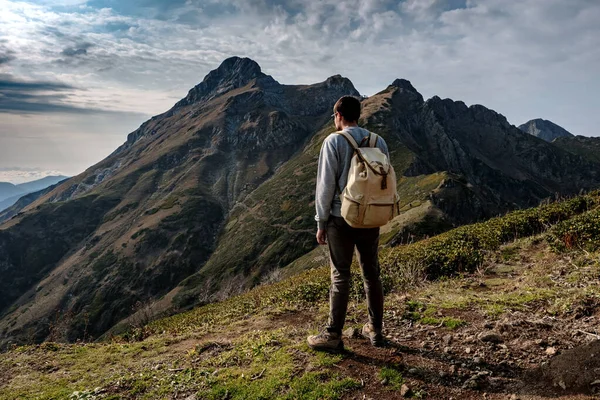 Joven de pie en la cima de las montañas del acantilado — Foto de Stock