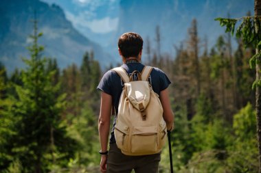 Man hiking at mountains with heavy backpack