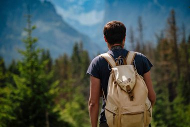 Man hiking at mountains with heavy backpack