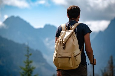 Man hiking at mountains with heavy backpack