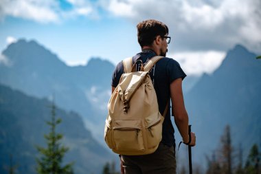 Man hiking at mountains with heavy backpack
