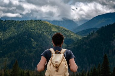 Man hiking at mountains with heavy backpack