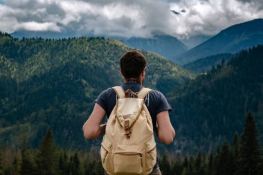 Man hiking at mountains with heavy backpack
