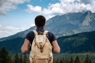 Man hiking at mountains with heavy backpack