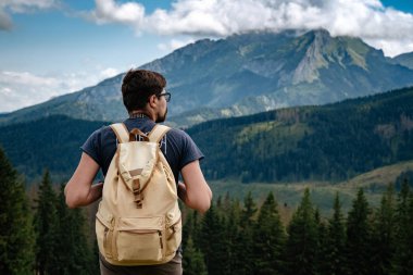 Man hiking at mountains with heavy backpack