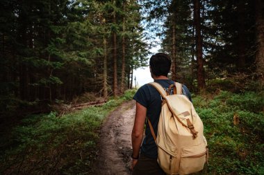 Man hiking at mountains with heavy backpack