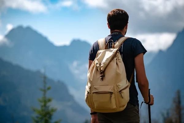 Hombre senderismo en las montañas con mochila pesada — Foto de Stock