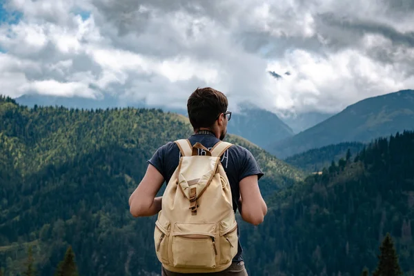 Hombre senderismo en las montañas con mochila pesada — Foto de Stock
