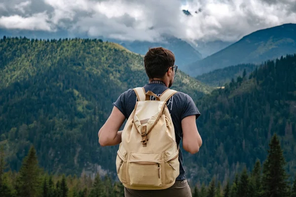 Man hiking at mountains with heavy backpack