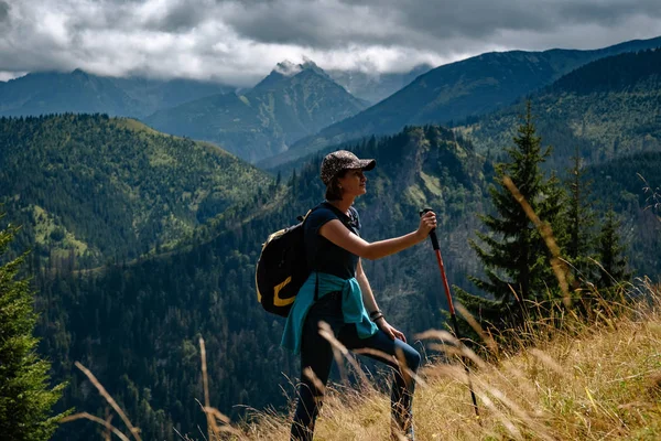 Uma jovem mulher está subindo uma montanha. — Fotografia de Stock