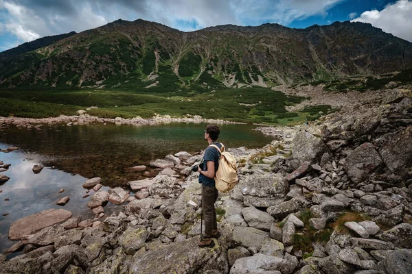 Man Traveler with backpack near mountain lake — Stock Photo, Image