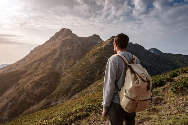 Genç adam uçurumun tepesinde duruyor.
