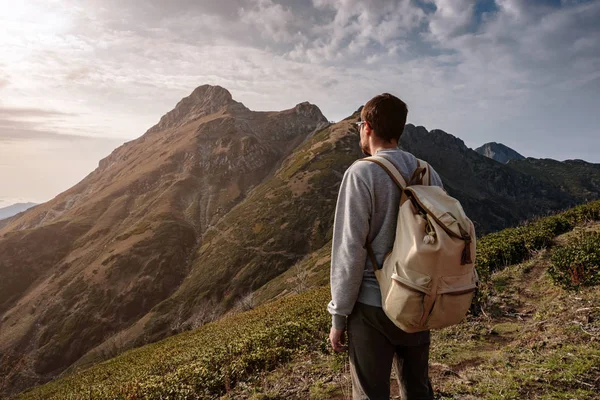 Genç adam uçurumun tepesinde duruyor.