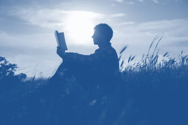 Güzel romantik gün batımına karşı bulutlu bir adamın silueti.