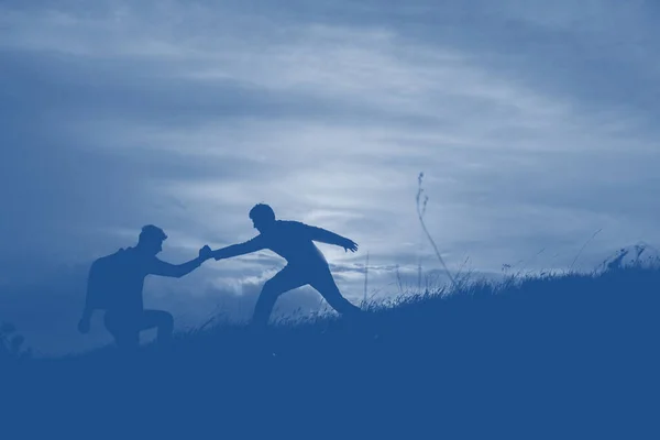 La silueta de los hombres contra el cielo hermoso romántico de la puesta del sol con las nubes . —  Fotos de Stock