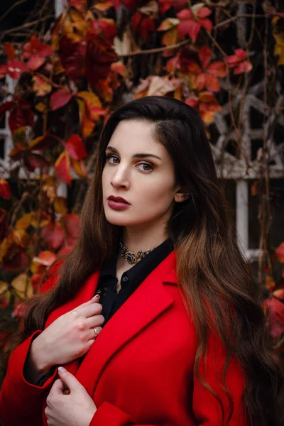 Красивая молодая женщина в красном пальто наслаждается осенним парком . — стоковое фото