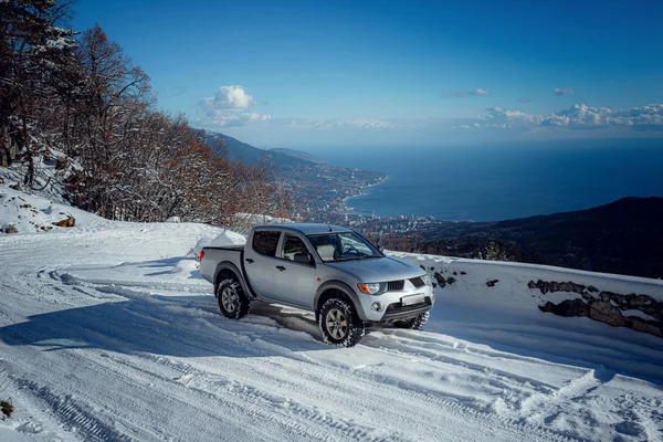 Pickup truck on road, Beautiful winter road under snow mountains.