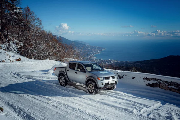 Pickup truck on road, Beautiful winter road under snow mountains.