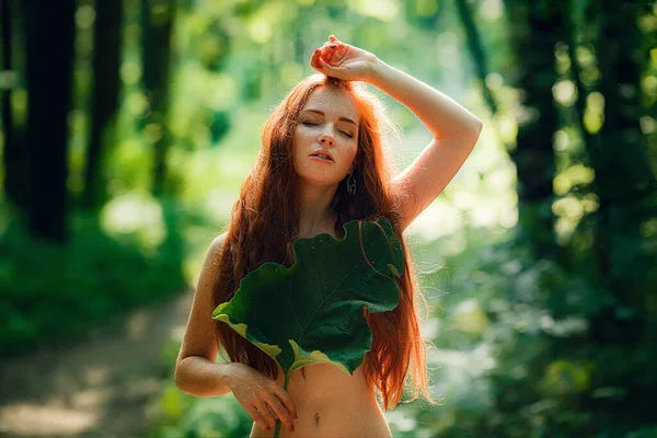 A young ginger woman stand in the green forest. — Stock Photo, Image