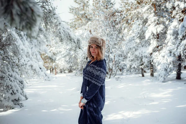 Красива дівчина стоїть, взимку в лісовому парку, на фоні снігу ялинки — стокове фото