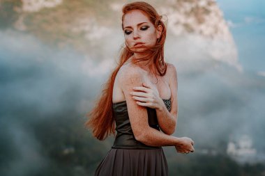 Güzel, öfkeli İskandinav savaşçı, gri elbiseli, metal zırhlı, kızıl saçlı kadın. Kadın bir Viking. Fantezi. Kitap kapağı. Yakın plan portre. Sinematik görünüm