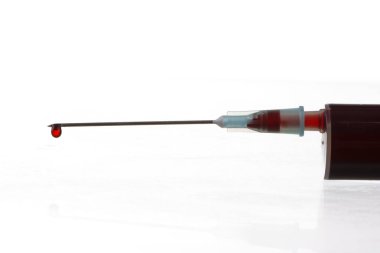 Beyaz arka planda şırıngadaki kan damlasının makro görüntüsü. Kan kimyası. Virüsler için kan testi.