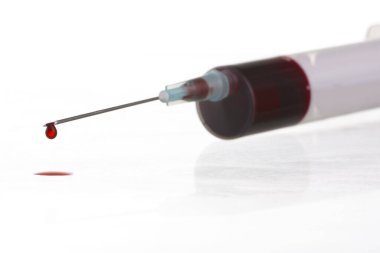 Beyaz arka planda şırıngadaki kan damlasının makro görüntüsü. Kan kimyası. Virüsler için kan testi.