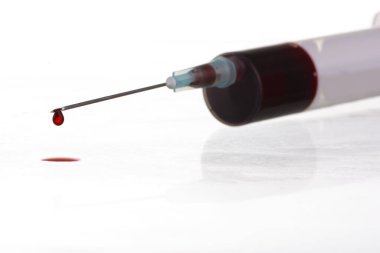 Beyaz arka planda şırıngadaki kan damlasının makro görüntüsü. Kan kimyası. Virüsler için kan testi.