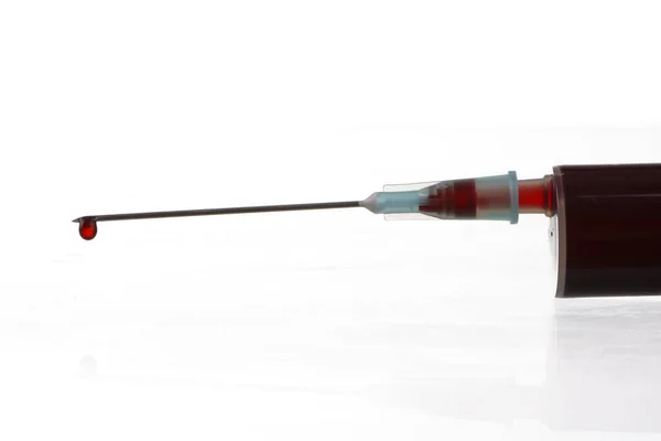 stock image Macro view of drop of blood from syringe over white background. Blood chemistry. Blood test for viruses.