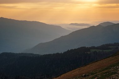 Kuzey Kafkasya 'da sonbahar, sezon dışında Rosa Khutor kayak merkezi. Rusya, Soçi. Klasik tonlama. Seyahat geçmişi. Turuncu bulutların ve sislerin arasından parlayan güneş ışığıyla manzara.