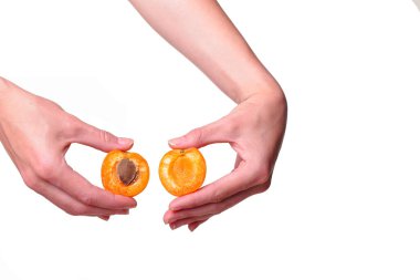 Beyaz arka planda lezzetli kayısı olan bir kadın eli. El ve tedavi için krem veya organik sağlıklı gıda fikri ve konsepti