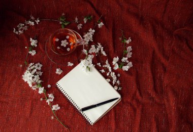 Spring bemol üst kattaki ofis çalışma alanı - kırmızı masa arkasında çay fincanı ve kiraz çiçeği dalları olan defter