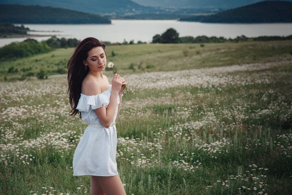 Hermosa Joven Morena Vestido Blanco Está Disfrutando Primavera Campo Margaritas — Foto de Stock