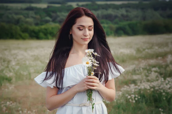 Hermosa Joven Morena Vestido Blanco Está Disfrutando Primavera Campo Margaritas —  Fotos de Stock