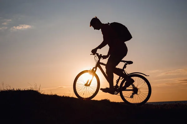 Silhouette of cyclist in motion at beautiful sunset. The idea and concept of a healthy lifestyle, exercise for health and quarantine exemptions