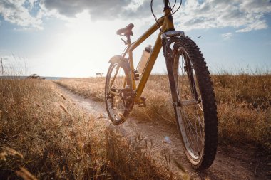Motosiklet silueti kırsaldaki gün batımı toprak yolunda. Fikir ve konsept fiziksel aktivite ve sağlıklı yaşam tarzı