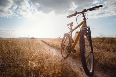 Motosiklet silueti kırsaldaki gün batımı toprak yolunda. Fikir ve konsept fiziksel aktivite ve sağlıklı yaşam tarzı
