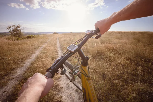 Bike handle bar with lake and sunshine in the background. focus on bike handle bar. picturesque village road at sunset