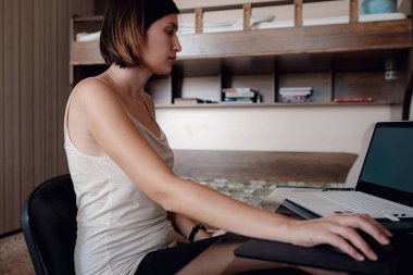 Çevrimiçi eğitim ve çalışma mesafesi. Ofiste çalışan mutlu bir kadın evden uzakta çalışıyor. dizüstü bilgisayar yazılımı, web sörf bilgileri ya da internet mağazasından alışveriş.