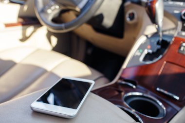 Araba koltuğundaki akıllı telefon paneli. Arabada yaşam tarzı fotoğrafı var. Farklı görüşler. El olmadan, telefon..