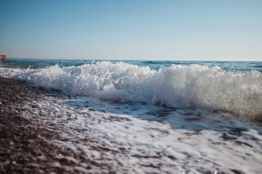Tropikal okyanusta güzel mavi dalgalar. Turkuaz dalga fıçısı denize çarpıyor. Kapat..