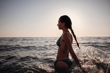 Güzel duygusal model kız denize su sıçratıyor ve gülüyor. Güzel Ateşli Kadın Okyanus Dalgaları 'nın tadını çıkarıyor. Tropik tatil