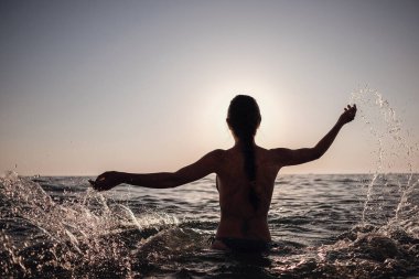 Güzel duygusal model kız denize su sıçratıyor ve gülüyor. Güzel Ateşli Kadın Okyanus Dalgaları 'nın tadını çıkarıyor. Tropik tatil