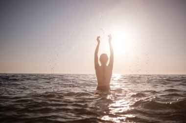Güzel duygusal model kız denize su sıçratıyor ve gülüyor. Güzel Ateşli Kadın Okyanus Dalgaları 'nın tadını çıkarıyor. Tropik tatil