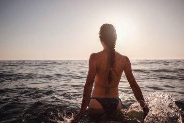 Güzel duygusal model kız denize su sıçratıyor ve gülüyor. Güzel Ateşli Kadın Okyanus Dalgaları 'nın tadını çıkarıyor. Tropik tatil