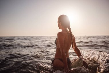 Güzel duygusal model kız denize su sıçratıyor ve gülüyor. Güzel Ateşli Kadın Okyanus Dalgaları 'nın tadını çıkarıyor. Tropik tatil
