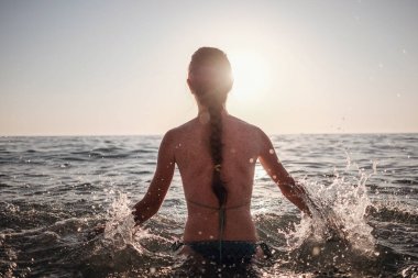 Güzel duygusal model kız denize su sıçratıyor ve gülüyor. Güzel Ateşli Kadın Okyanus Dalgaları 'nın tadını çıkarıyor. Tropik tatil