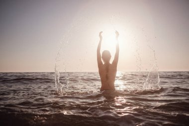 Güzel duygusal model kız denize su sıçratıyor ve gülüyor. Güzel Ateşli Kadın Okyanus Dalgaları 'nın tadını çıkarıyor. Tropik tatil