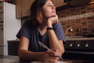 Evden çalışmak, kişisel izolasyon, çevrimiçi öğrenme kavramı. Asyalı Kadın serbest ders veriyor ve evde, mutfakta dizüstü bilgisayar üzerinde çalışıyor. Karantina için evinizde kalın..