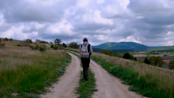 Turista csizmák Megy az úton a háttér egy gyönyörű táj. — Stock videók